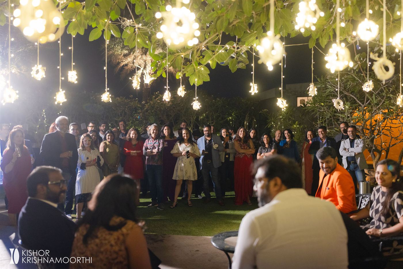 Tablers and families gathered under fairy lights at the 500th meeting