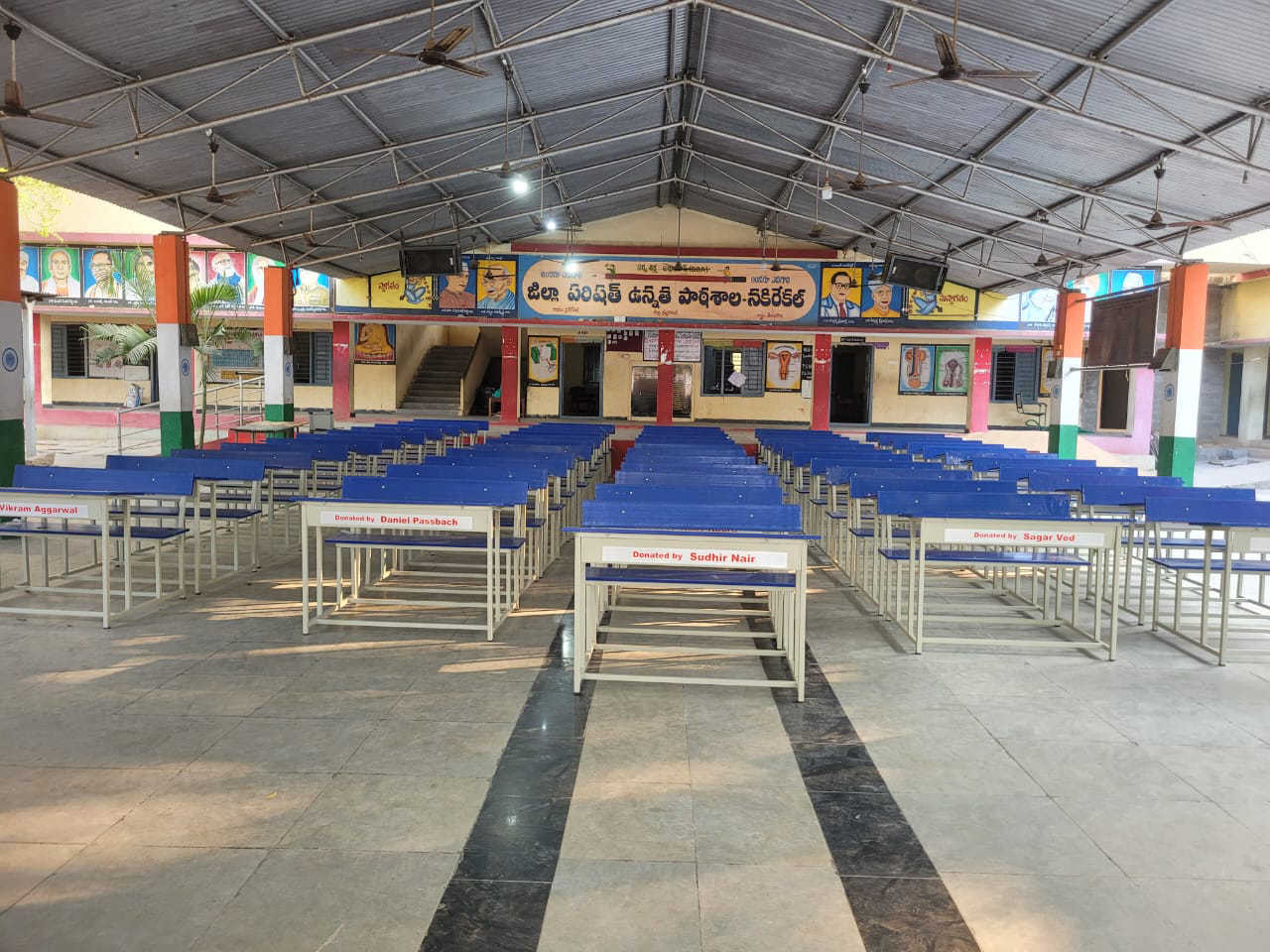 Rows of new blue benches in a school assembly hall